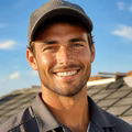 Portrait of a smiling young roofer in a cap.