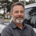 Portrait of an experienced contractor standing beside his work truck.