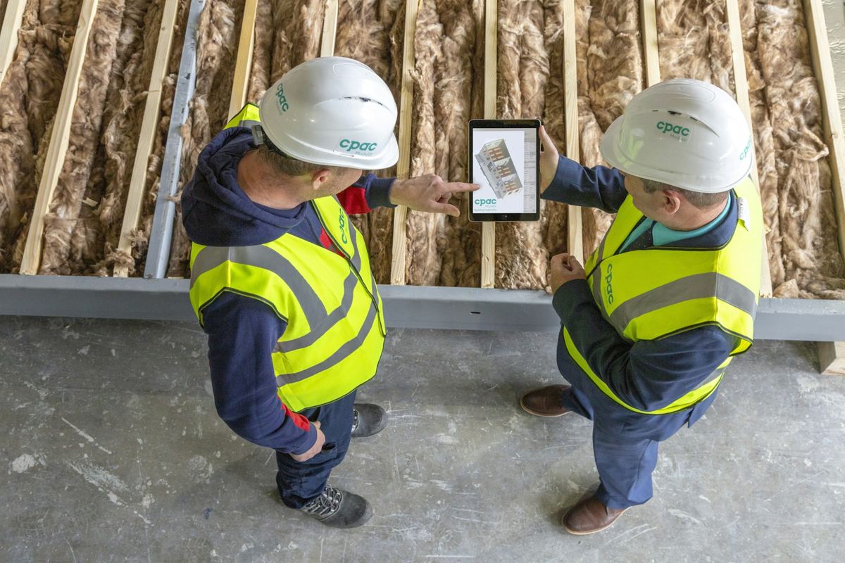 Two workers reviewing a tablet
